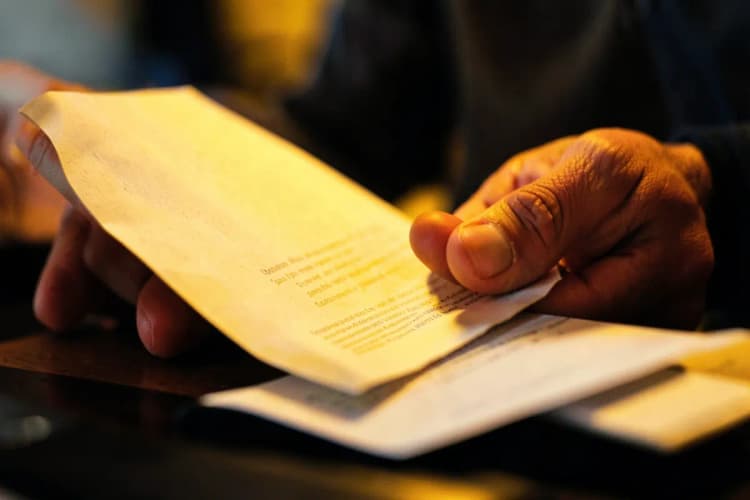Pessoa lendo os requisitos para o curso de motorista de ambulância em um papel